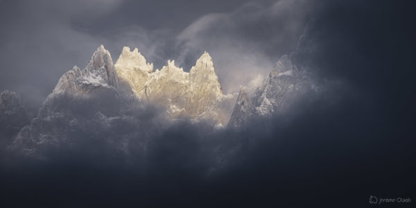 Les Aiguilles de Chamonix émergent des nuages en hiver sous la neige
