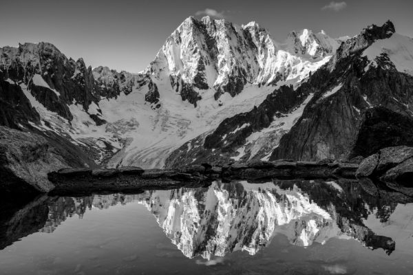 La face nord des Grandes Jorasses se reflète dans un lac en noir et blanc